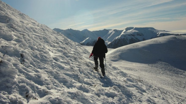 hombre caminando por una montana de nieve